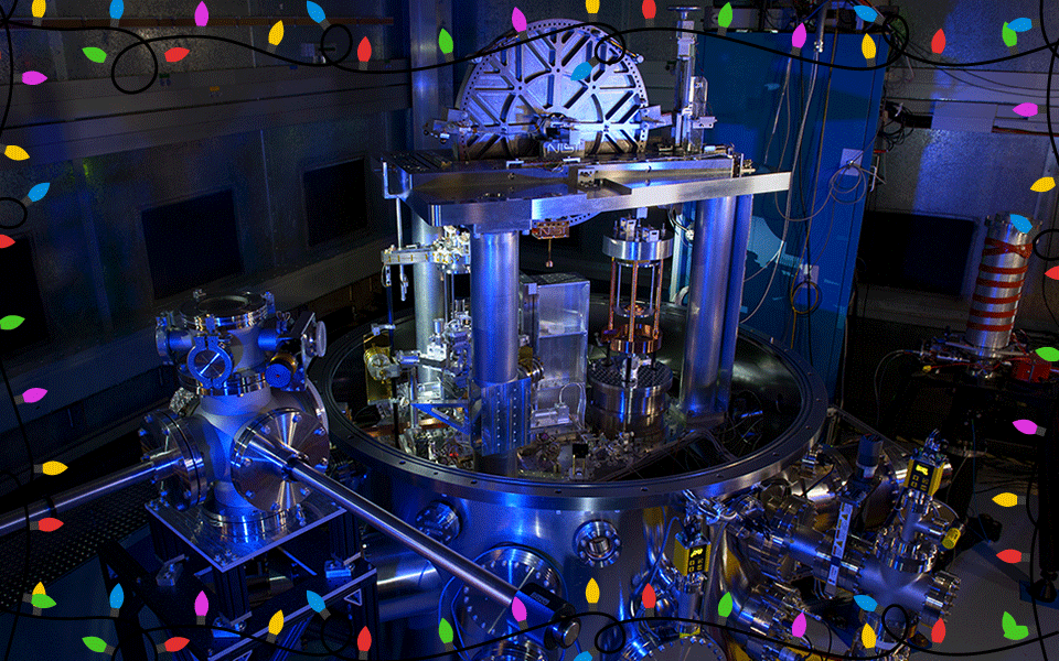 A large, intricate metal measurement device is in a dark room with blue light. 