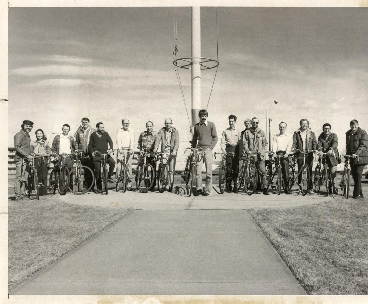 A group of 16 people with their bikes