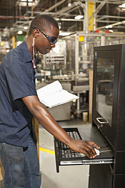 Man at Computer on Manufacturing Floor