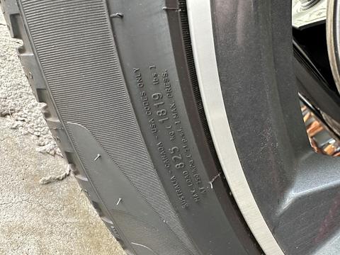 Close-up of a car tire with the pressure information stamped on in raised letters. 
