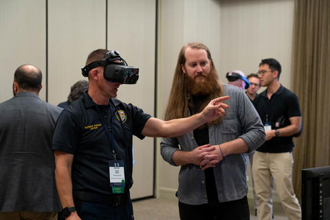 A 5x5 attendee tries out virtual reality equipment during a tech demo.