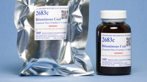 Photograph of a labeled mylar envelop and labeled amber bottle containing SRM 2683c Bituminous Coal. 