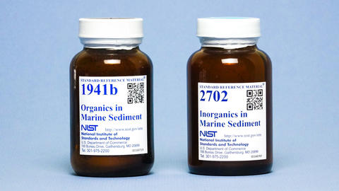 Photograph of two labeled amber bottles containing marine sediments.