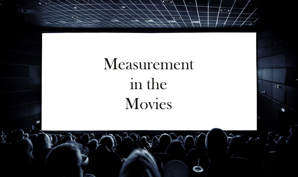 View from the back of a darkened movie theater shows the heads of the audience and a screen reading: Measurement in the Movies.