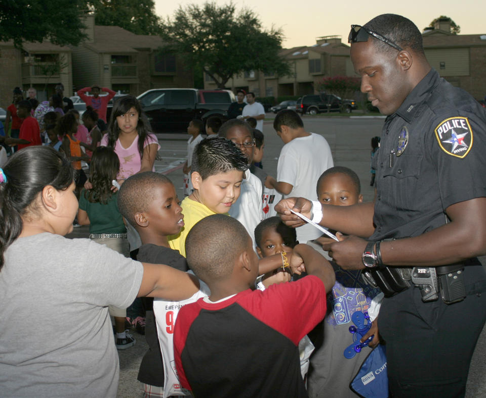 City of Irving, Texas photo of police officer talking to kids in the neighborhood.