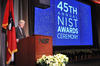 Under Secretary of Commerce for Standards and Technology and NIST Director Walter G. Copan at a podium in front of a screen showing the words 45th Annual NIST Awards Ceremony.