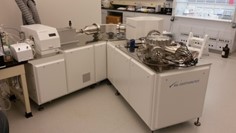 Photograph of laboratory instrument consisting of modular cabinets, vacuum chambers, and plasma chamber. 