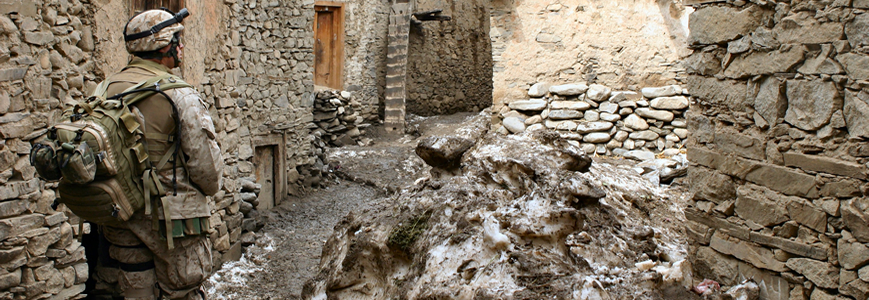 soldier walking through stone buildings