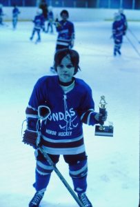 Small boy in hockey uniform at ice rink