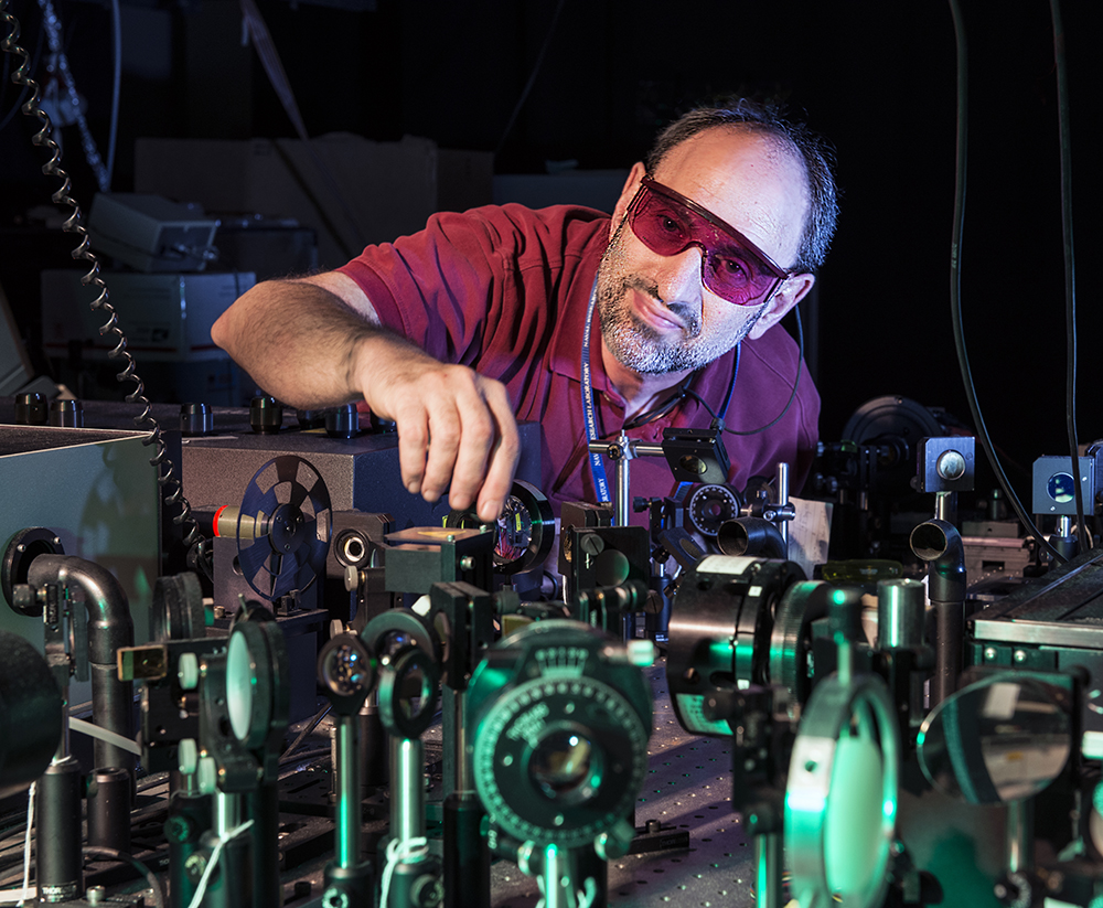 Ted Heilweil wearing protective glasses adjusting optics at a laser table.