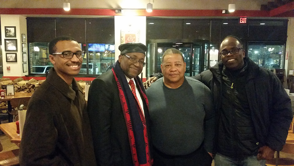 Four men smiling and posing for a photo