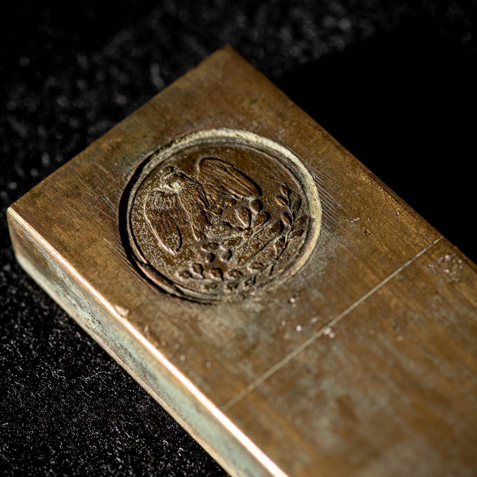 The great seal of Mexico, a golden eagle perched on a cactus, holding a rattlesnake in its talons. 