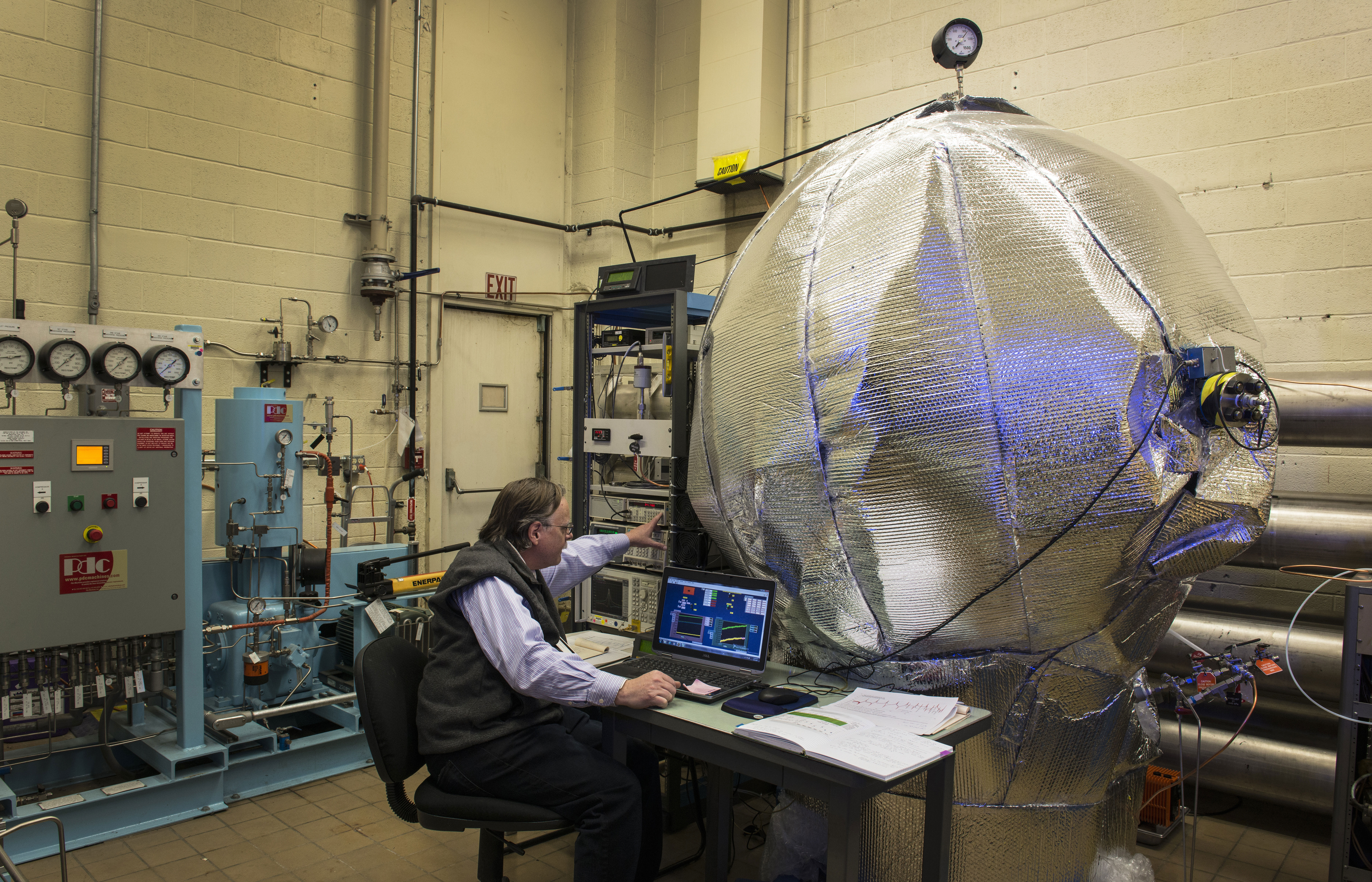 Photo of NIST scientist with the big blue ball covered in thermal insulation.