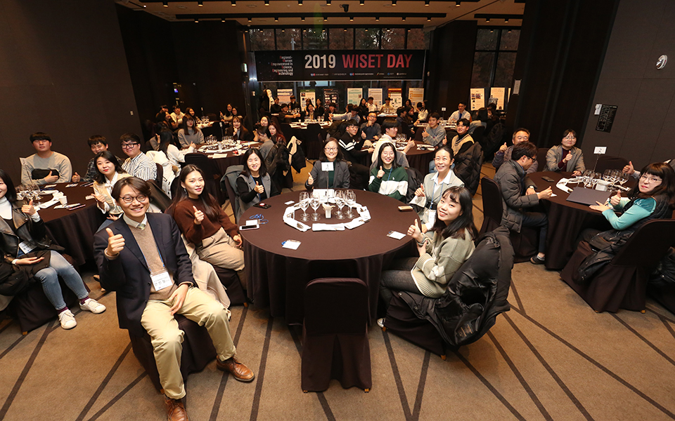 Group of Korean students in a small meeting room giving the "thumbs up" sign