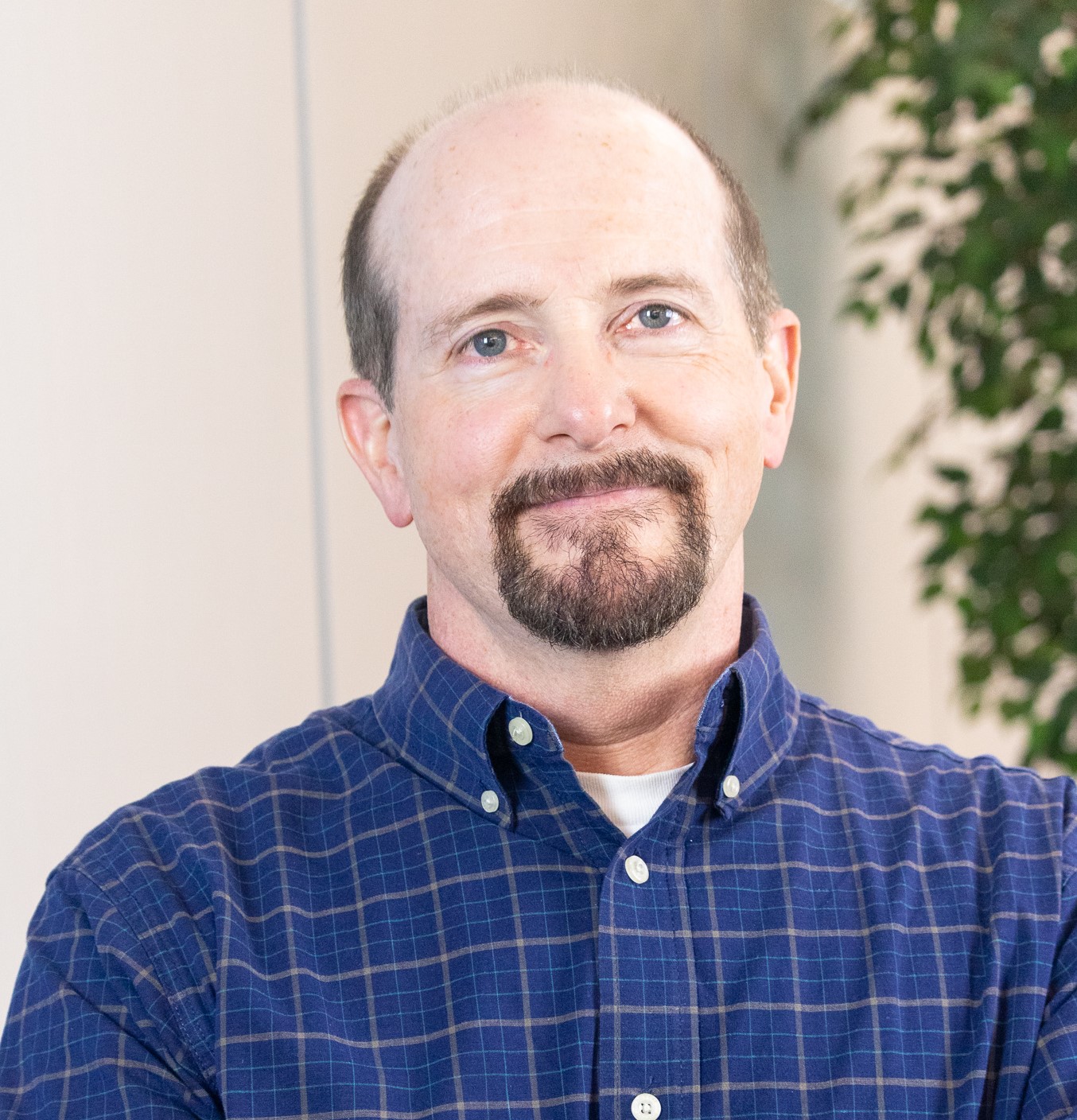 This image shows a man in a blue button up shirt.