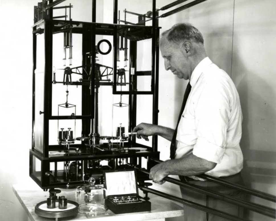 researcher loading weights onto a balance scale