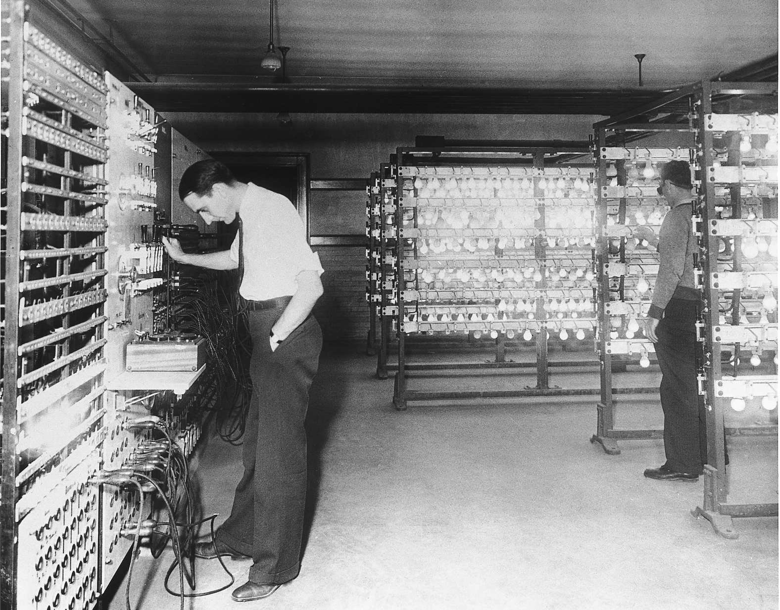 two researchers examining instruments in a laboratory filled with illuminated lightbulbs