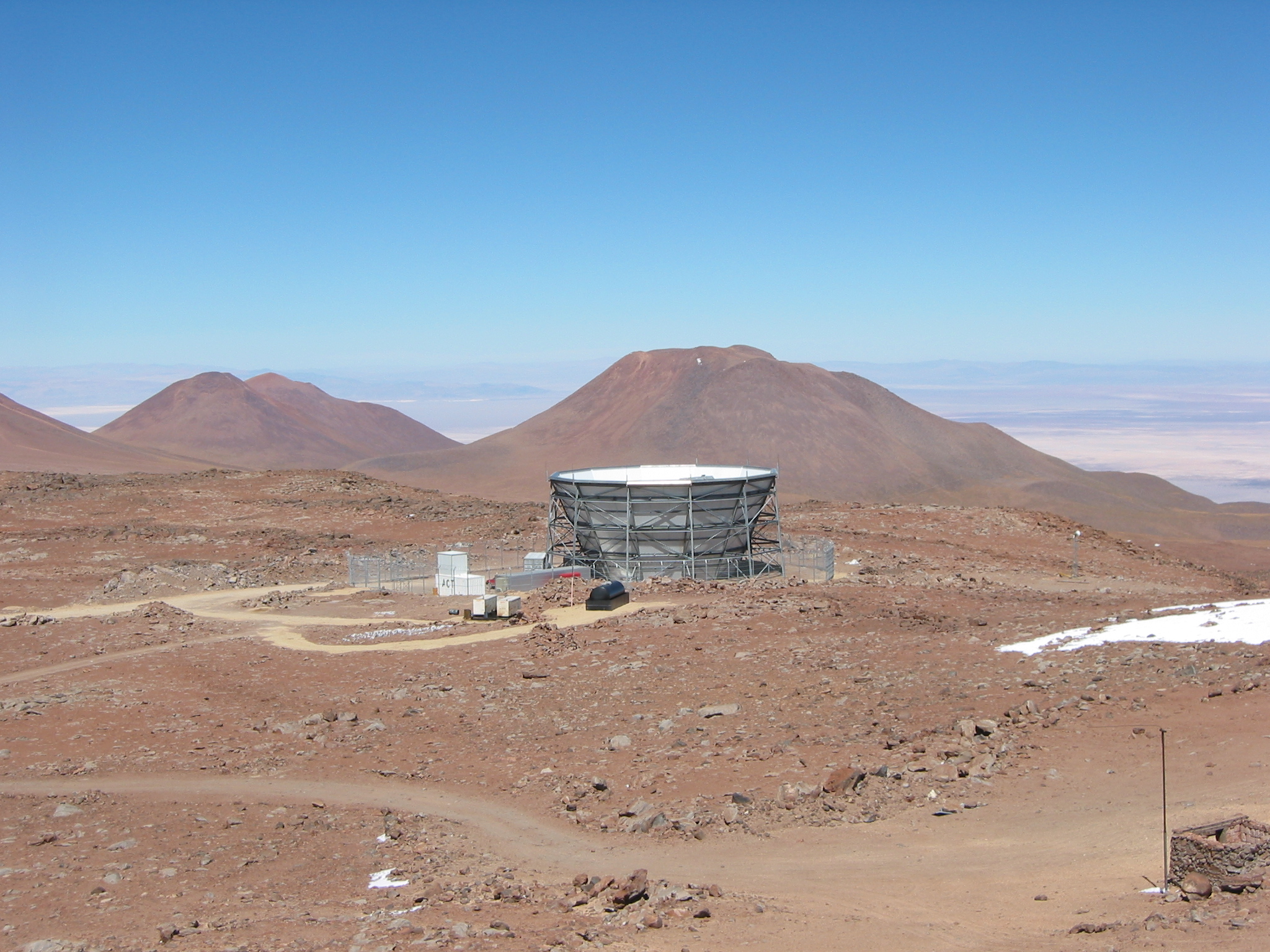 Large dish points upward in rocky desert with mountains in the background.