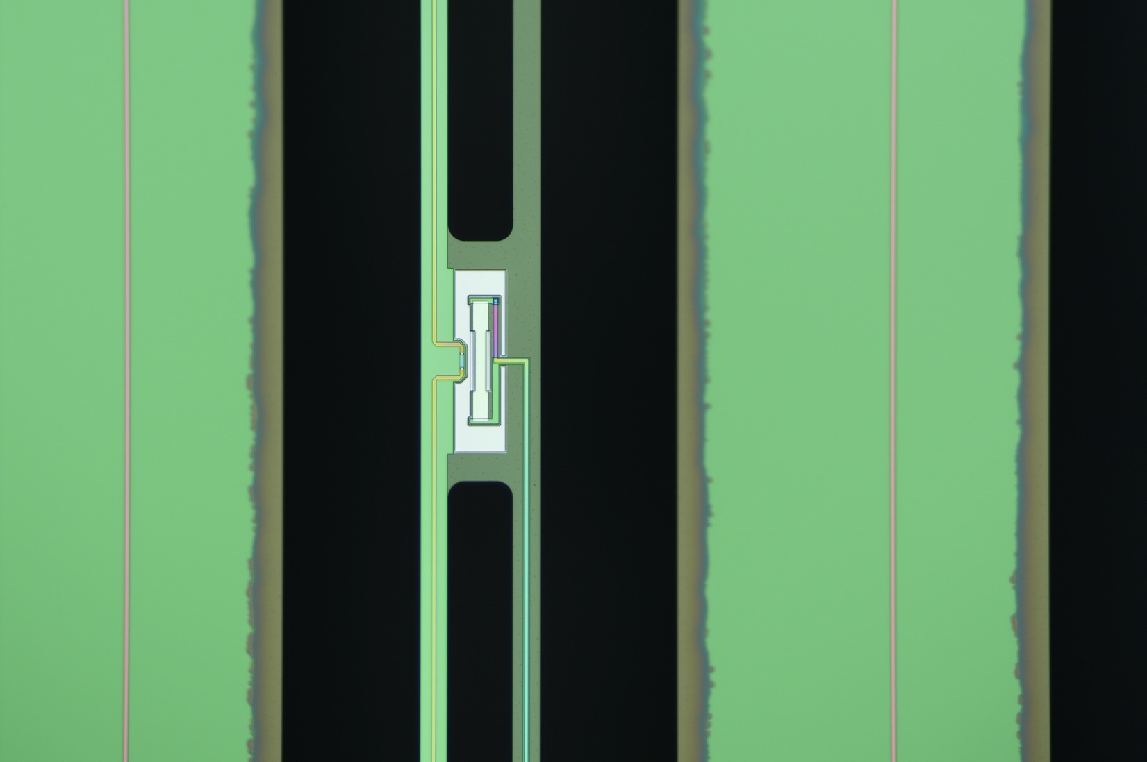 Metallic rectangle is surrounded by green and black vertical stripes of varying widths. 