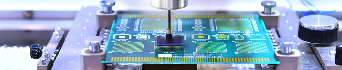 A semiconductor chip is held in a metal frame while a device works on its surface.
