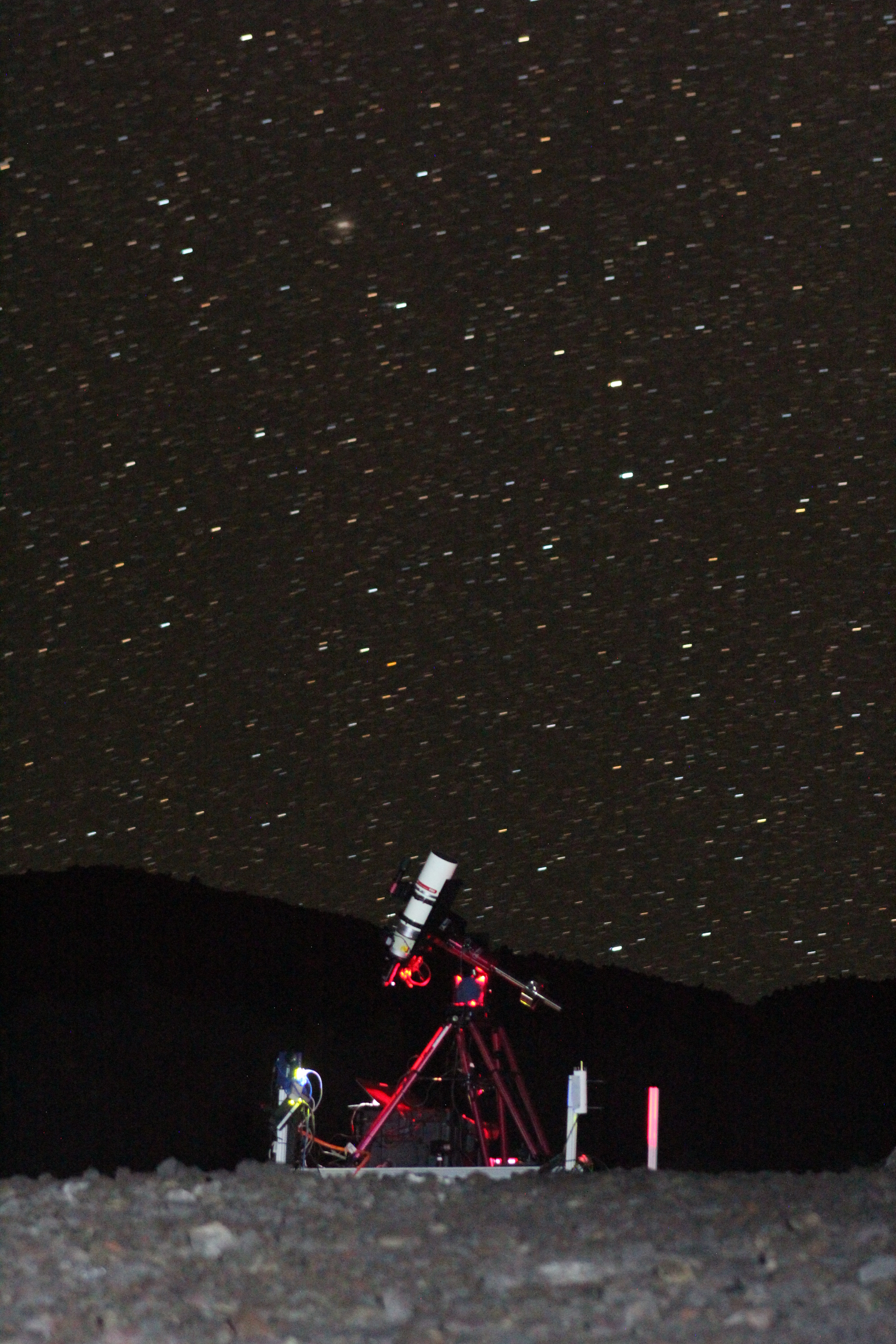 An instrument on a red scaffold stands in front of a starry night sky.