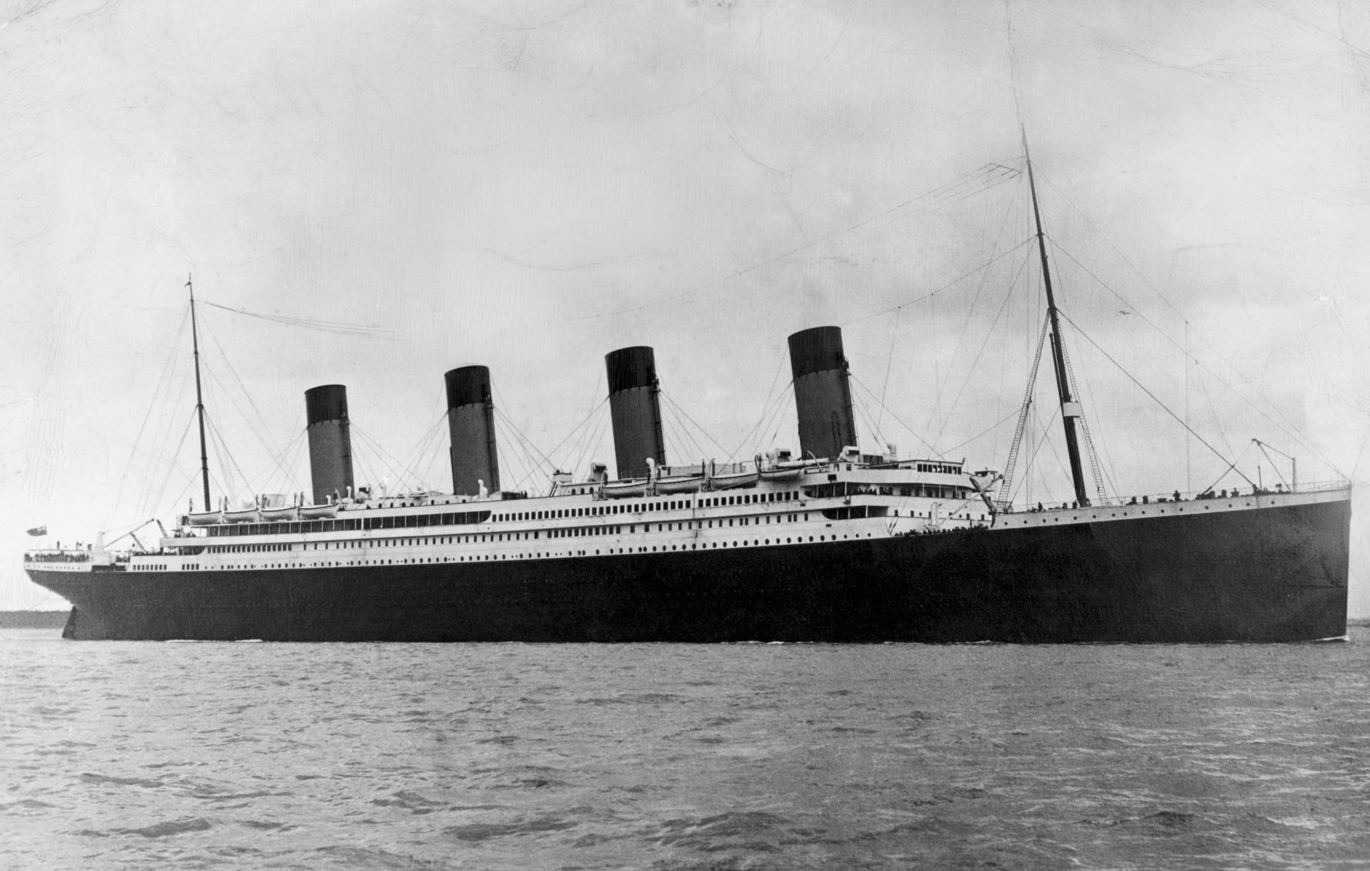 Historical photo shows RMS Titanic from the side, with four prominent funnels.