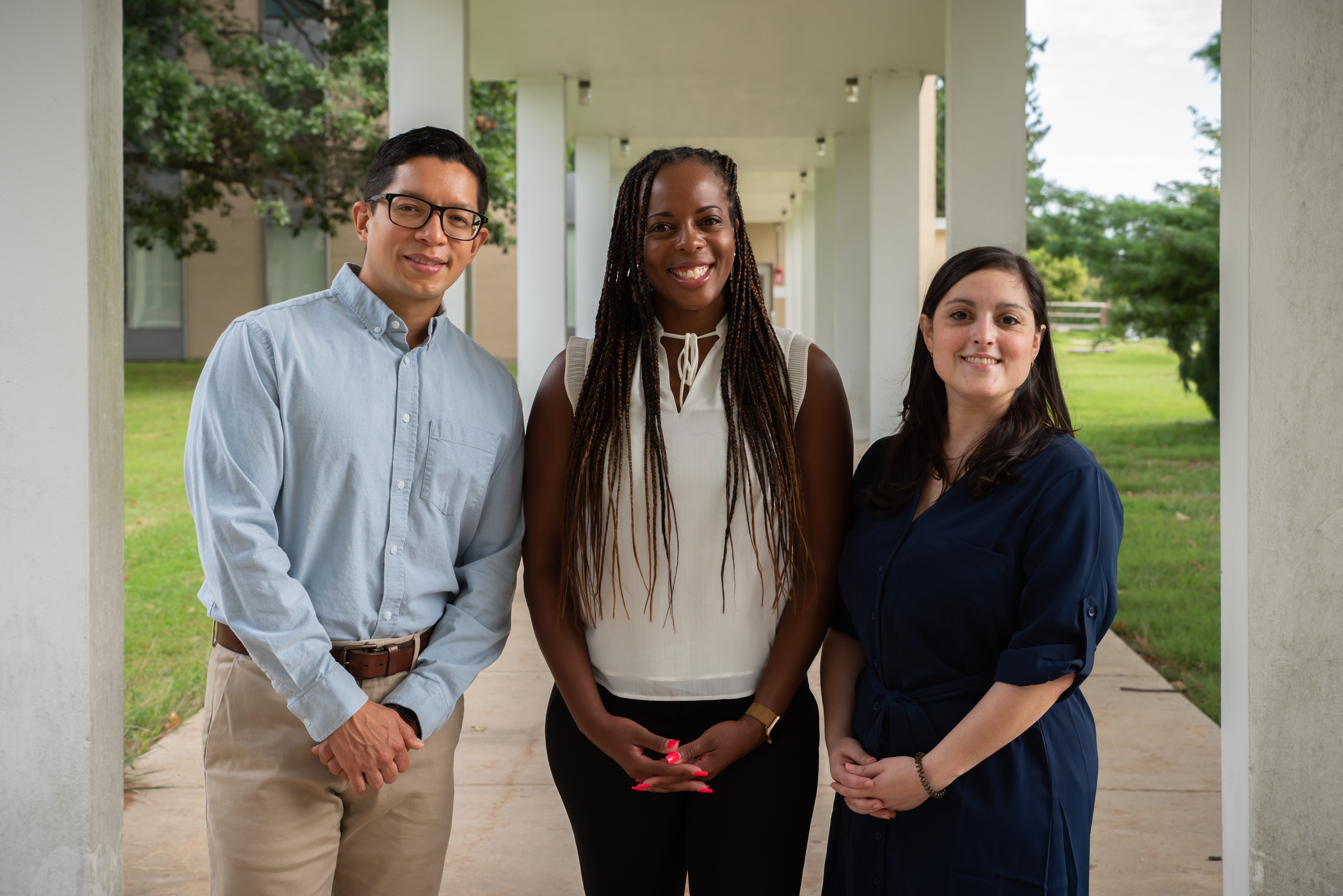 Juan Fung, Jeanita Pritchett and Carina Hahn pose for a group photo outside on the NIST campus. 