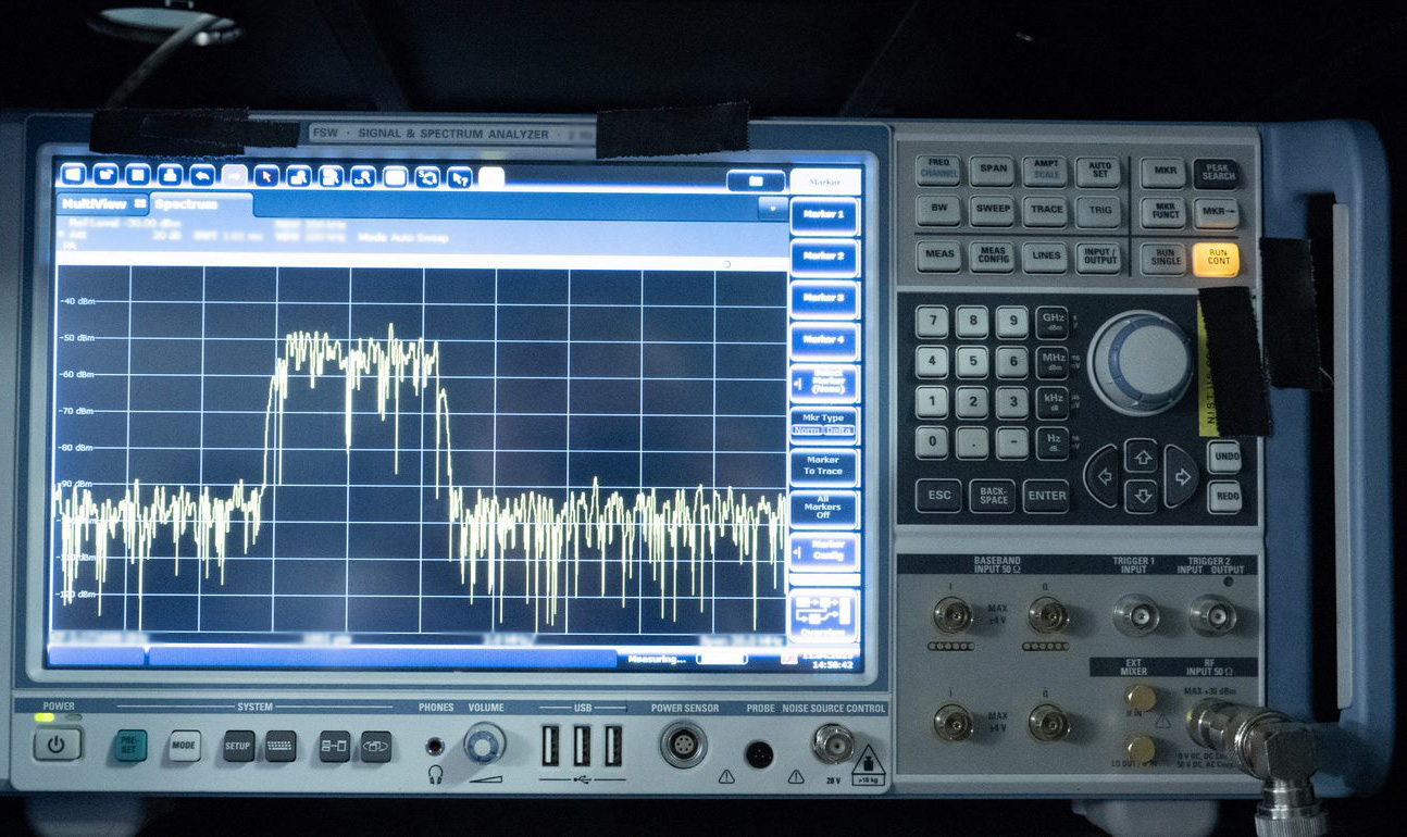 Radio signal analyzer has screen on the left, showing a wave chart, and buttons and dials on the right. 