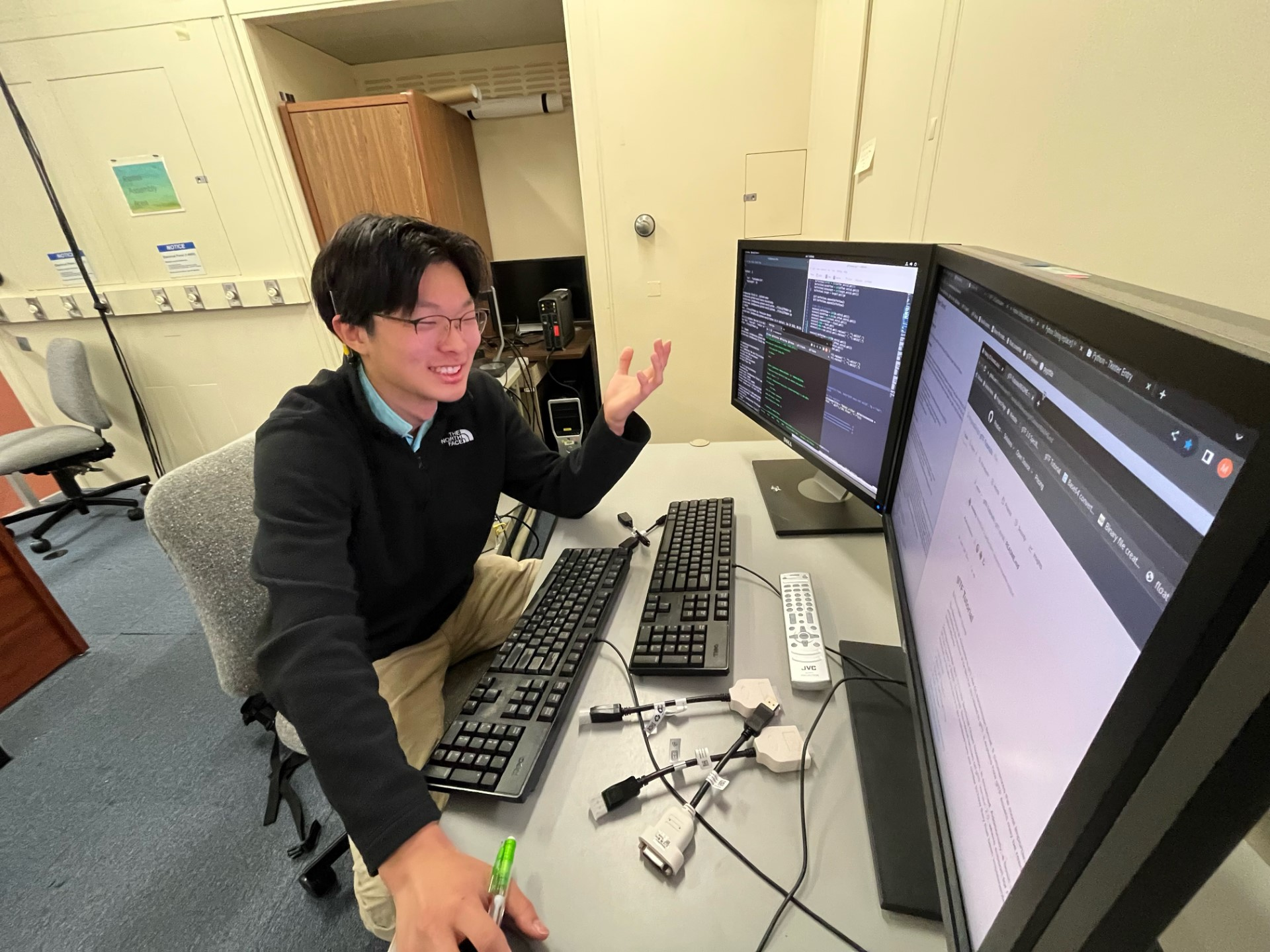 Morgan Ko sits at a desk with a computer and two monitors, smiling and gesturing as he speaks. 