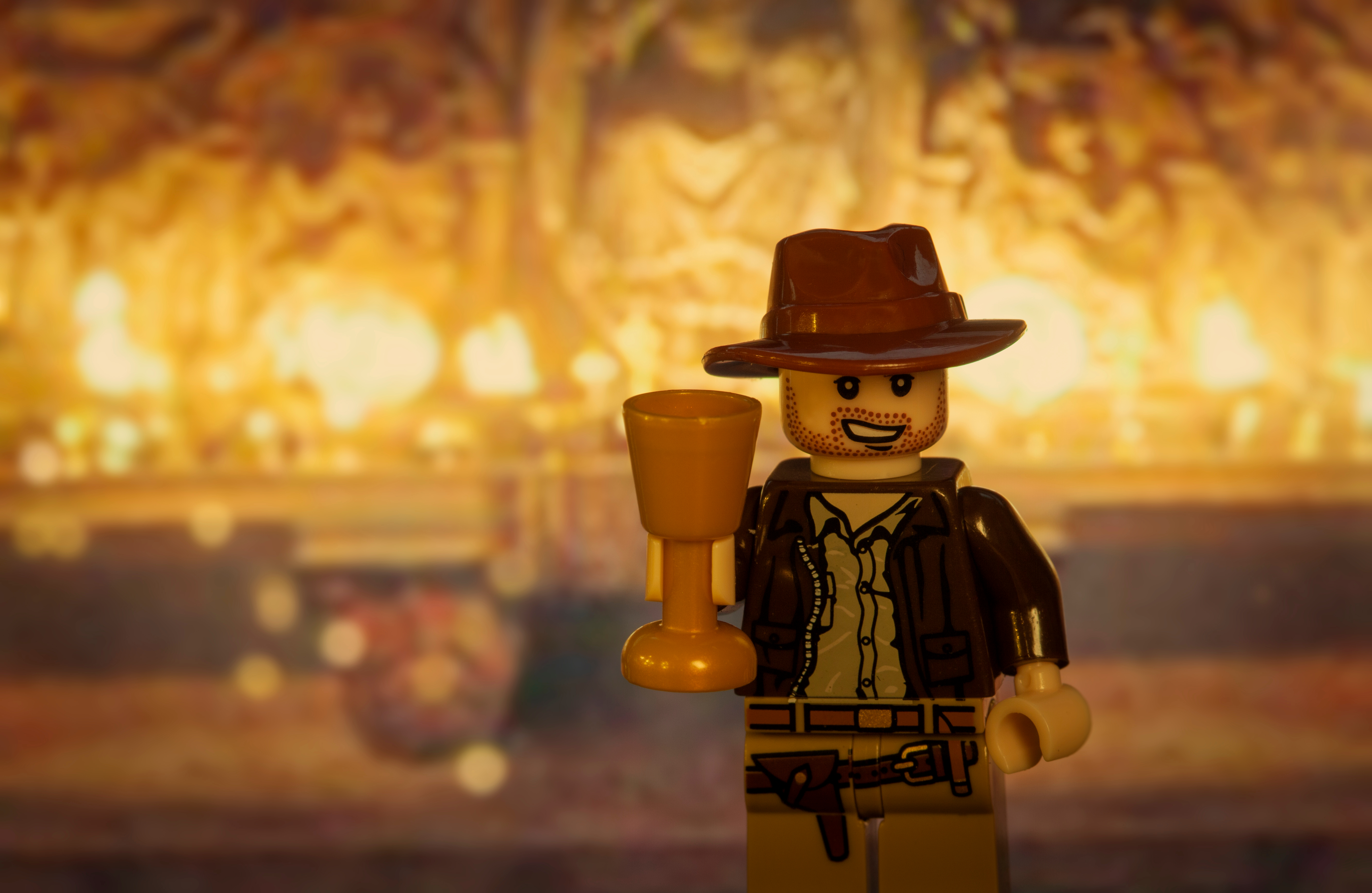 A Lego version of Indiana Jones is posed holding a cup representing the Holy Grail. 