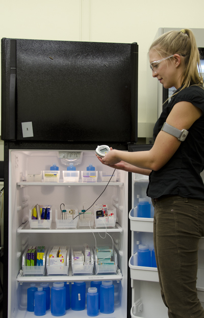 Physicist Michael Chojnacky checks a small digital unit in a test refrigerator.