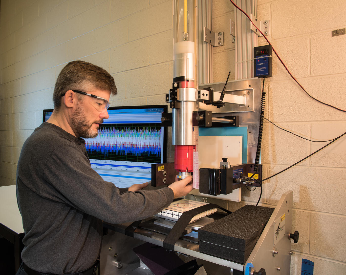 NIST Materials Scientist Michael Riley prepares a sample of material for a drop test