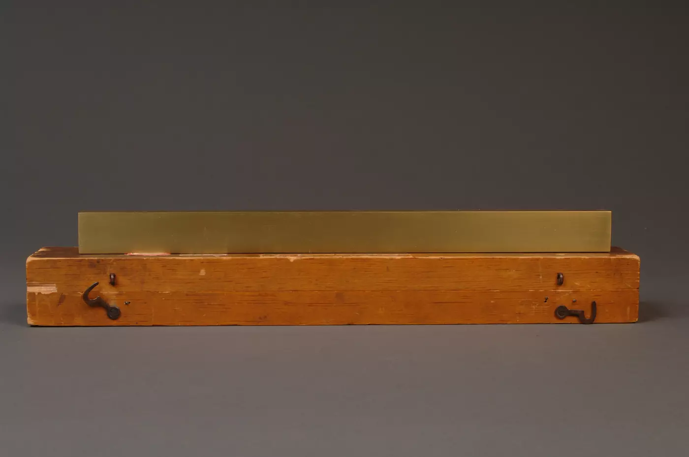 Brass line scale sitting on top of wooden box