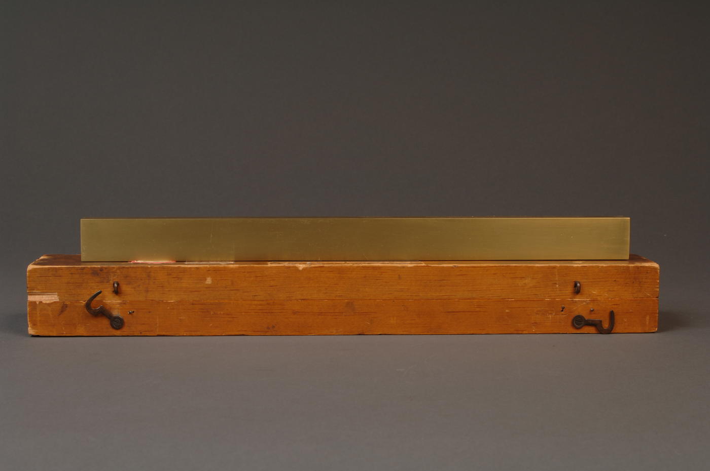 Brass line scale sitting on top of wooden box