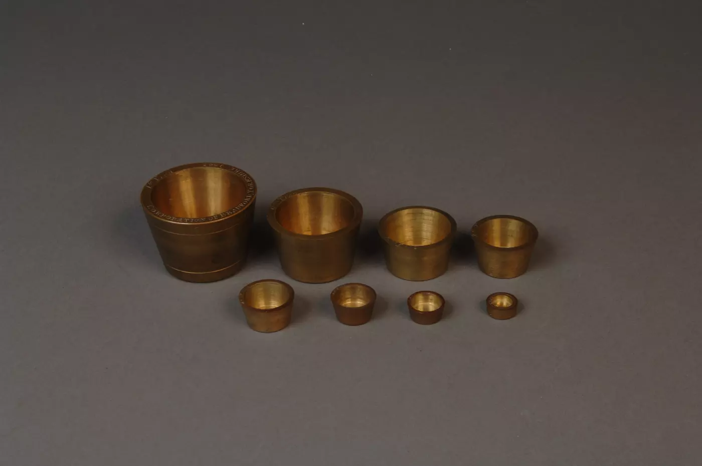 Eight troy standards arranged by size (largest to smallest)