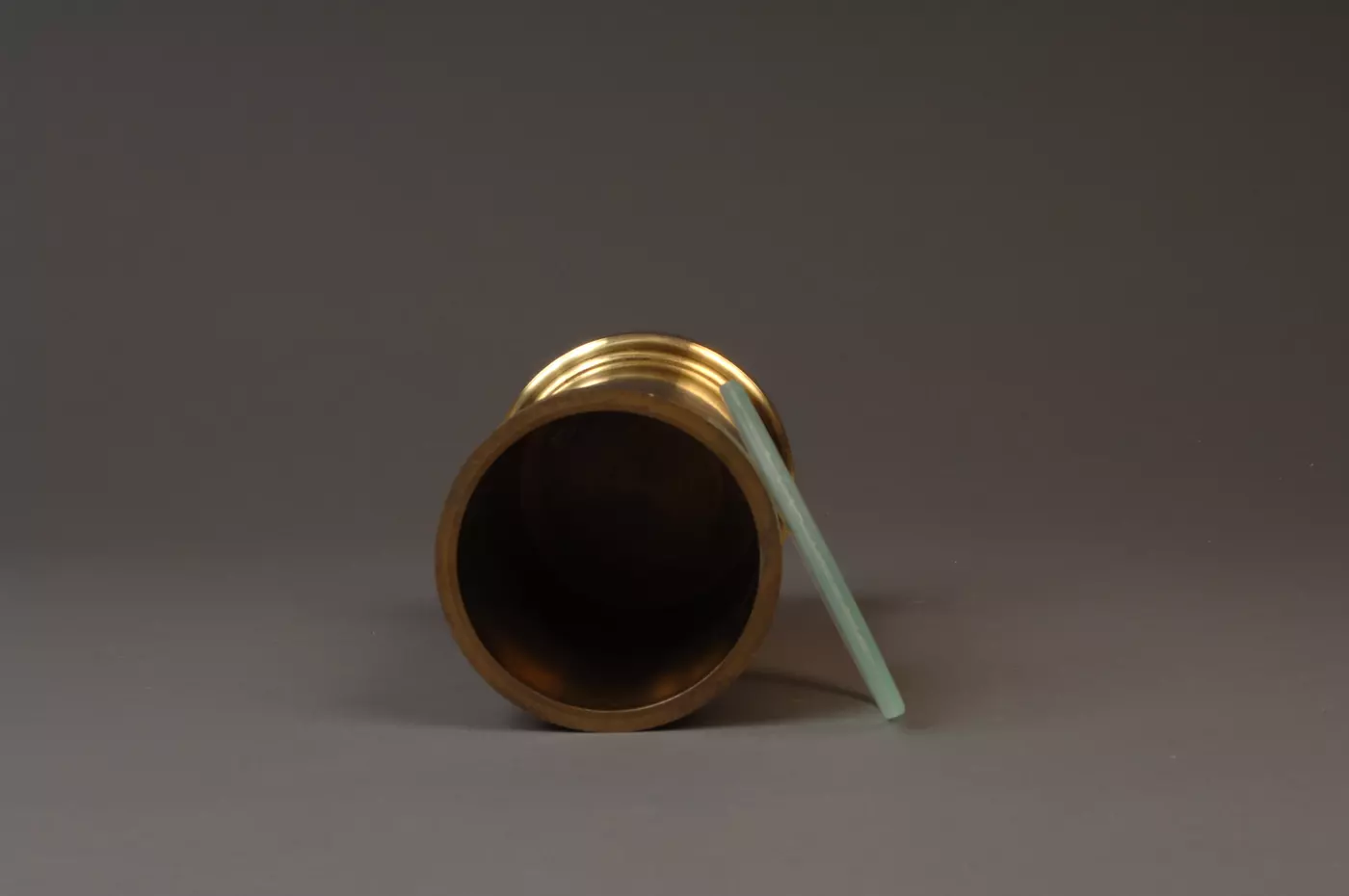 Brass volumetric standard, top view with glass cover laying at side