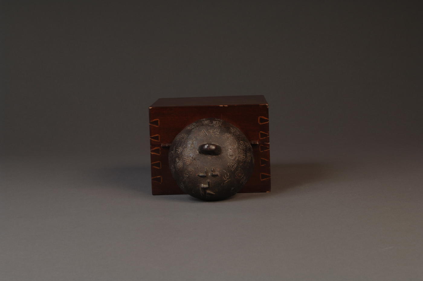 Bronze weight with Chinese writing in front of accompanying box