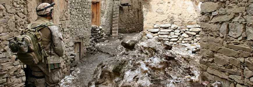 soldier walking through stone buildings