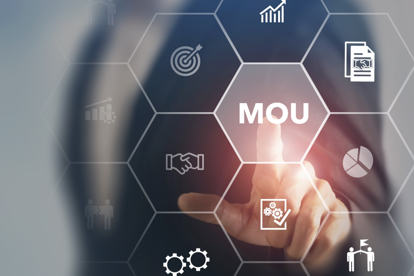 a person taps the words "MOU (Memoranda of Understanding)" on a virtual screen. "MOU" is surrounded by images that suggest collaboration, goals, and business. 