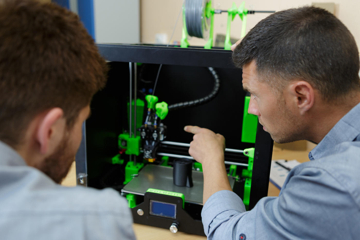 two researchers work at a 3D printer