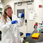 Researcher working in lab with safety glasses and gloves