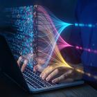 Hands rest on a laptop keyboard beneath a floating overlay of computer code and connecting lines.