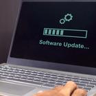 A laptop screen displays the words “software update” with a progress bar. 