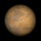 Color-enhanced photo of Mars shows the planet with patches of orange and brown. 