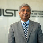 NIST director standing in front of the NIST logo