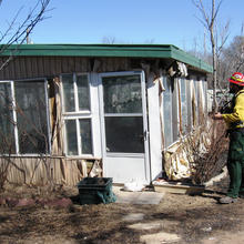 A member of a joint NIST-Texas Forest Service study team collects data on a Amarillo, Texas, building damaged by wildfires in February 2011.