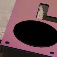 The circular patch of carbon nanotubes on a pink silicon backing is one component of NIST's new cryogenic radiometer, shown with a quarter for scale.