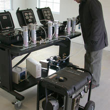 A NIST researcher adjusts a multi-gas analyzer which will measure carbon monoxide, oxygen, carbon dioxide and hydrocarbons concentrations produced by such a generator located, against safety advice, in a garage.