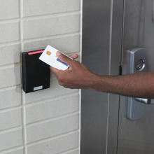 Photo of a person holding a PIV card up to a reader