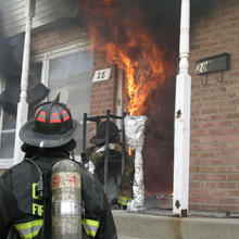 Flames from a living-room pour out the front door of a townhouse during a NIST test.